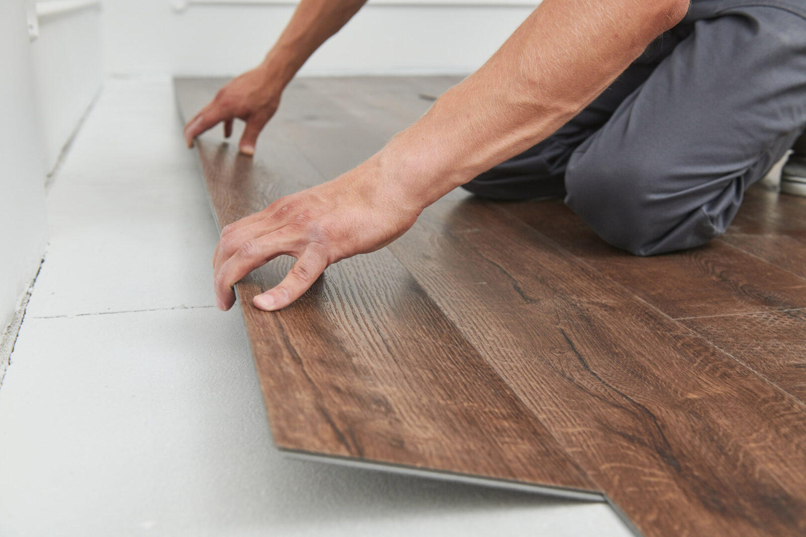 worker joining vinyl floor covering at home renovation